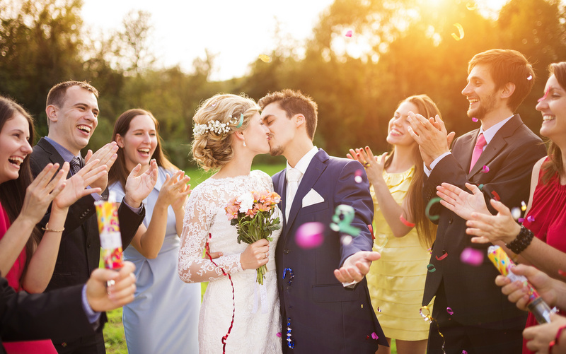para młoda całująca się na weselu z gości w około